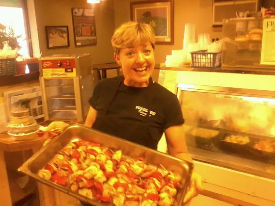 A Fressers team member holding a tray of fresh-baked food