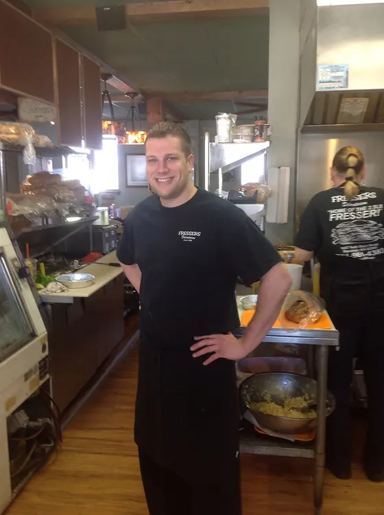 A Fressers team member smiling behind the counter