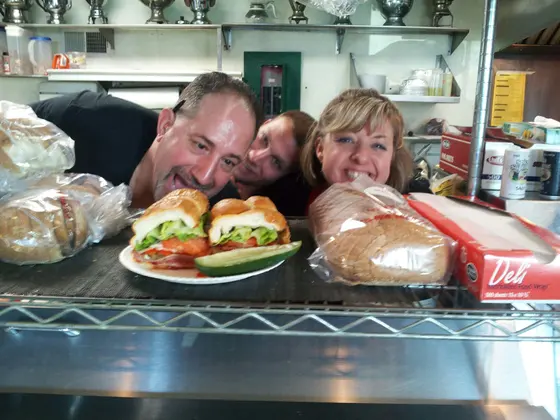 Fressers staff and customers posing with a sandwich