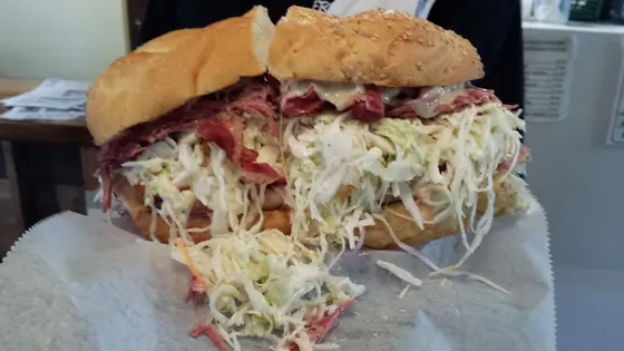 Hand-stacked pastrami sandwich with coleslaw